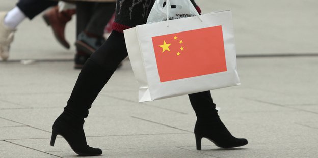 Eine Frau hat eine Tüte mit der chinesischen Flagge in der Hand
