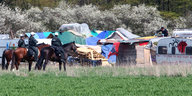 Berittene Polizisten stehen vor Zelten vor dem Hambacher Forst