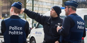 Drei Polizisten stehen auf der Straße