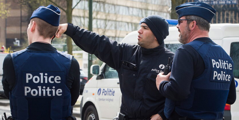 Drei Polizisten stehen auf der Straße