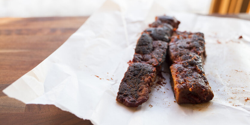 Auf einem Stück Papier liegen zwei Stücke von veganem Grillfleisch