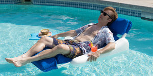 Ein Mann mit Sonnenbrille liegt auf einer Luftmatratze in einem Pool. Es ist Bob Odenkirk
