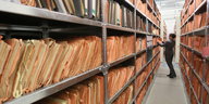 Eine Mitarbeiterin des Stasi-Museums steht im Stasi-Archiv in Berlin zwischen Regalen mit bisher nicht erfassten Unterlagen