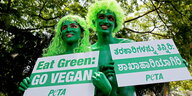 Peta-Aktivisten halten Pro-Vegan-Plakate in die Kamera