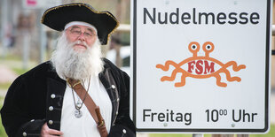 Ein als Pirat verkleideter Mann steht neben einem Schild mit der Aufschrift "Nudelmesse"