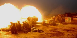 Soldaten feuern Artilleriegeschütze ab