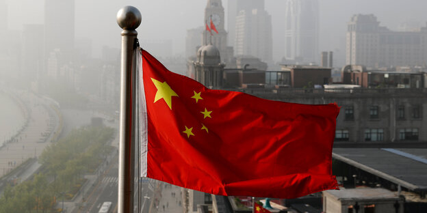 Chinas Flagge vor einer Skyline