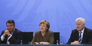 Sigmar Gabriel, Angela Merkel und Horst Seehofer sitzen vor einer blauen Wand