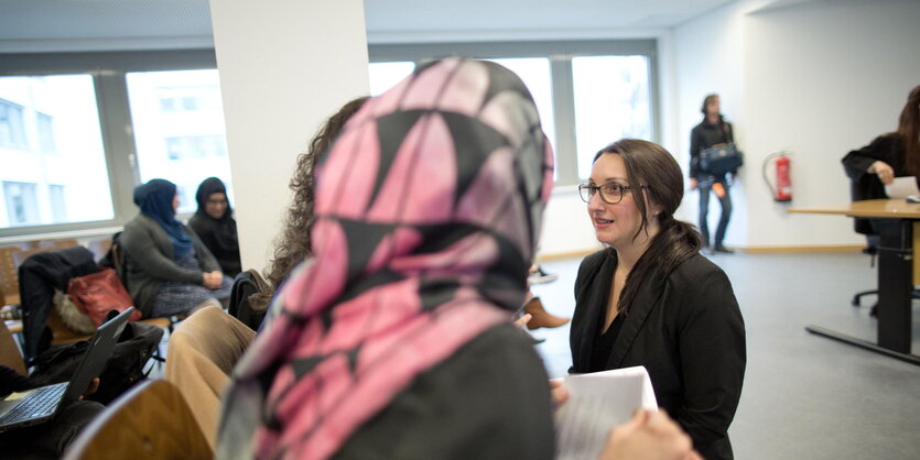 Die Rechtsanwältin Maryam Haschemi Yekani hockt am 14.04.2016 im Berliner Arbeitsgericht vor einer Frau mit Kopftuch