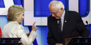 Hillary Clinton und Bernie Sanders vor blauem Hintergrund