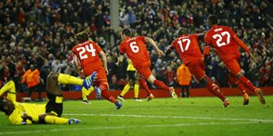 Vier Spieler des FC Liverpool in einer Reihe auf dem Fußballplatz, ein Spieler des BVB liegt am Boden