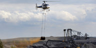 Hubschrauber überfliegt einen Tagebau