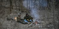 Zwei Soldaten an einem kleinen Lagerfeuer im Wald