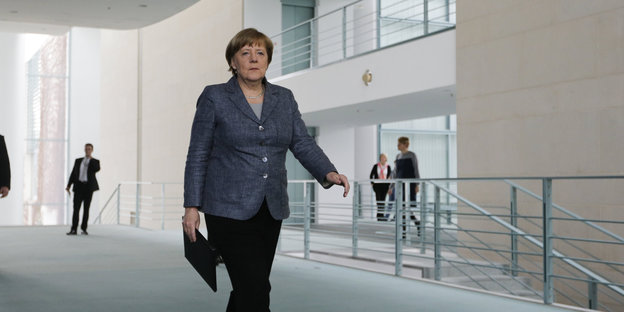 Angela Merkel durch einen Gang im Kanzleramt gehend