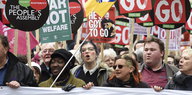 Männer und Frauen halten Schilder in die Höhe, auf denen unter anderem „Cameron must go“ steht