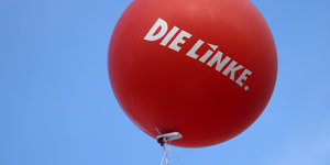 ein roter Luftballon mit der Aufschrift „Die Linke“ vor blauem Himmel
