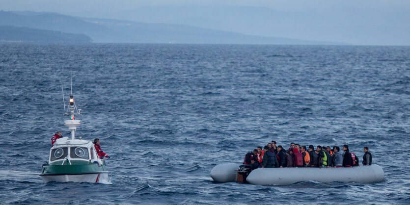 Ein Boot und ein Schlauchboot auf dem Meer, im Hintergrund Küste