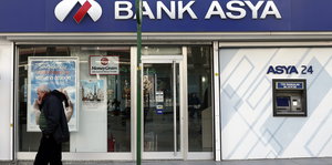 Ein Mann geht an einer Filiale der Bank Asya vorbei