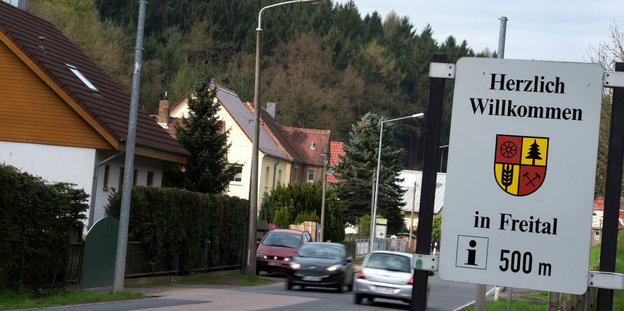 „Herzlich Willkommen in Freital“ steht auf einem Schild, dahinter Häuser und Autos