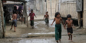 Rohingya-Kinder laufen in einem Camp nahe Sittwe im Westen Myanmars durch den Regen.