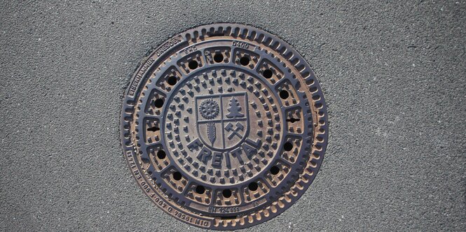 Ein Gullydeckel mit dem Wappen der Stadt Freital