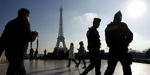 Sicherheitskräfte und Touristen vor dem Eiffelturm