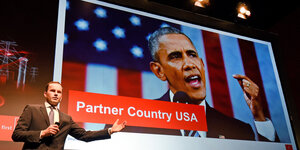 Jochen Köckler von der Messe Hannover vor einem Plakat von Obama