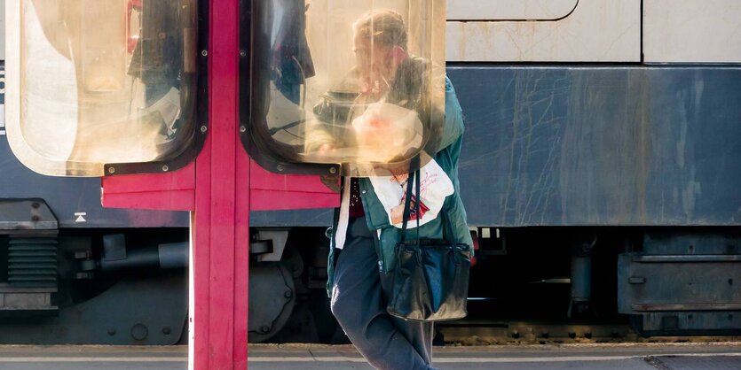 Eine Frau telefobniert an der Telefonzelle