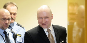 Anders Breivik betritt einen Raum und grinst