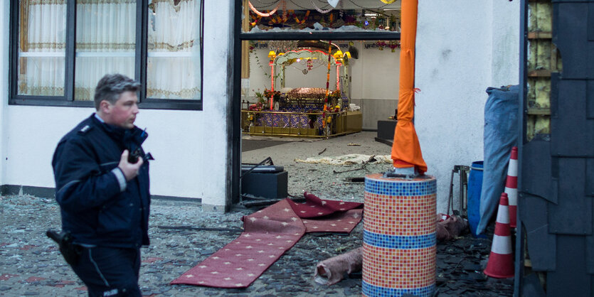 Ein Polizist läuft an einem Gebetshaus vorbei