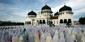 Viele Menschen beten vor einer Moschee in Indonesien