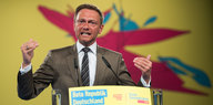 Lindner am Rednerpult vor buntem Hintergrund