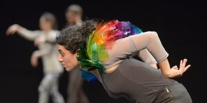 Performerin imitiert einen Regenbogen-Vogel