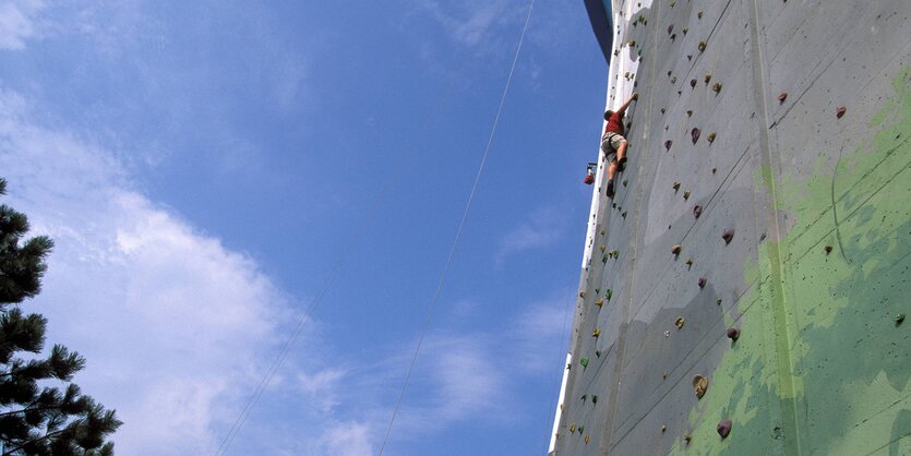 Ein Mann klettert im Freizeitpark im ehemaligen AKW Kalkar eine Steilwand am Kühlturm hoch