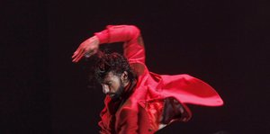 Ein Mann im roten Anzug tanzt wild