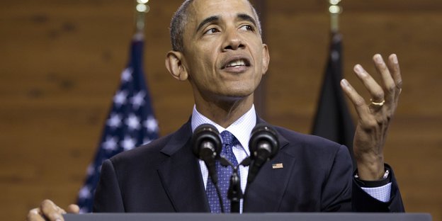 Ein Mann mit grauem Haar steht an einem Rednerpult. Es ist Barack Obama
