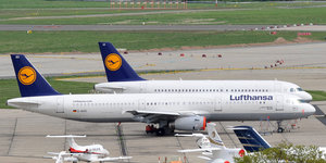 zwei Flugzeuge der Lufthansa stehen auf einem Flughafen