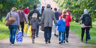 Von hinten zu sehen: eine Gruppe Menschen in bunter Kleidung