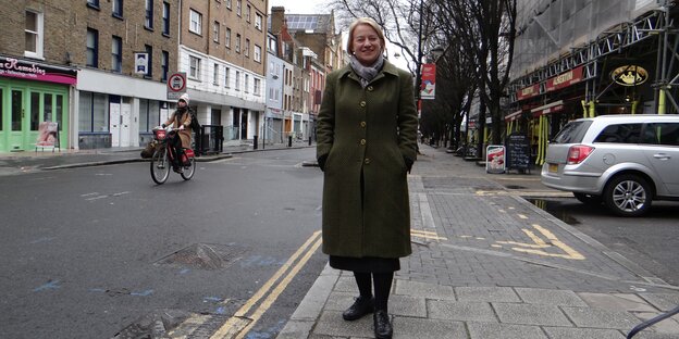 Grünenpolitikerin Natalie Bennett steht lachend auf einer Straße in Somers Town
