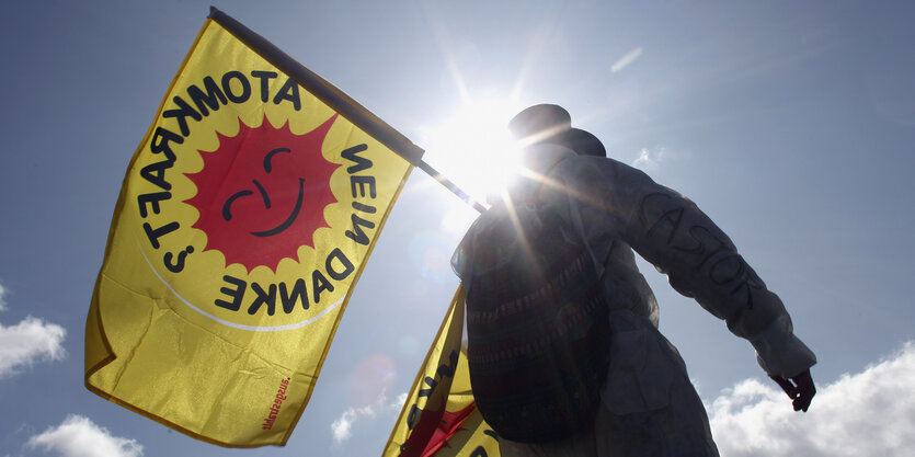 Ein Demonstrant trägt eine "Atomkraft, nein danke!"-Flagge.