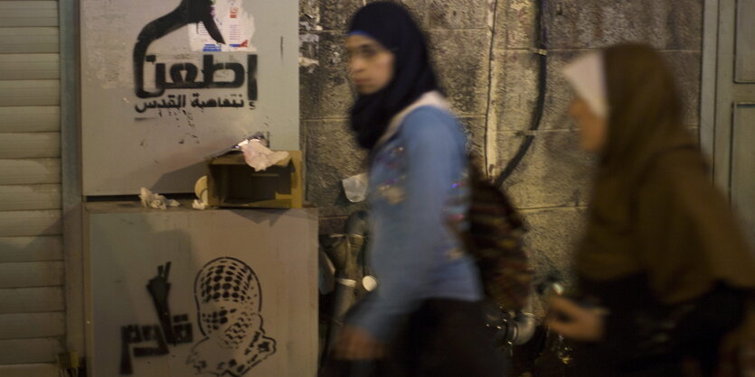 „Stechen, Jerusalem Inftifada“ lautet ein Graffiti an der Wand, zwei Frauen mit Kopftuch laufen vorbei