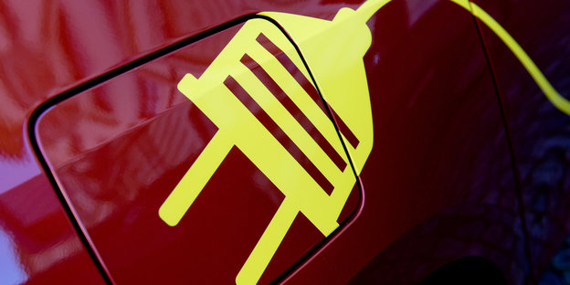 Auf einen roten Benzintankdeckel ist ein gelber Stecker gemalt