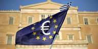 Vor einem großen Gebäude aus dem 19. Jahrhundert weht ein Fahne der Europäischen Union mit einem Euro-Symbol