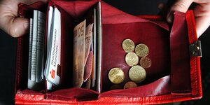 In einem geöffneten Portemonnaie befinden sich Scheine und Münzen