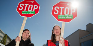 Zwei Frauen mit Stopschildern