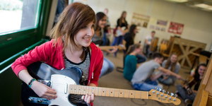 eine junge Frau mit einer E-Gitarre