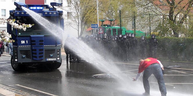 ein Wasserwerfer geht gegen einen Mann vor