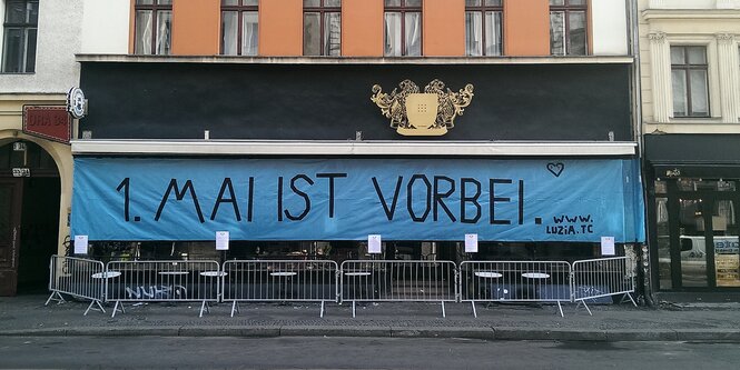 ein Plakat vor einer Kneiße, darauf steht "1. Mai ist vorbei"