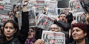 Menschen halten die Zeitung Cumhurriyet in die Höhe