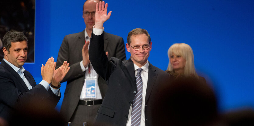 Michael Müller winkt von einer Bühne ins Publikum